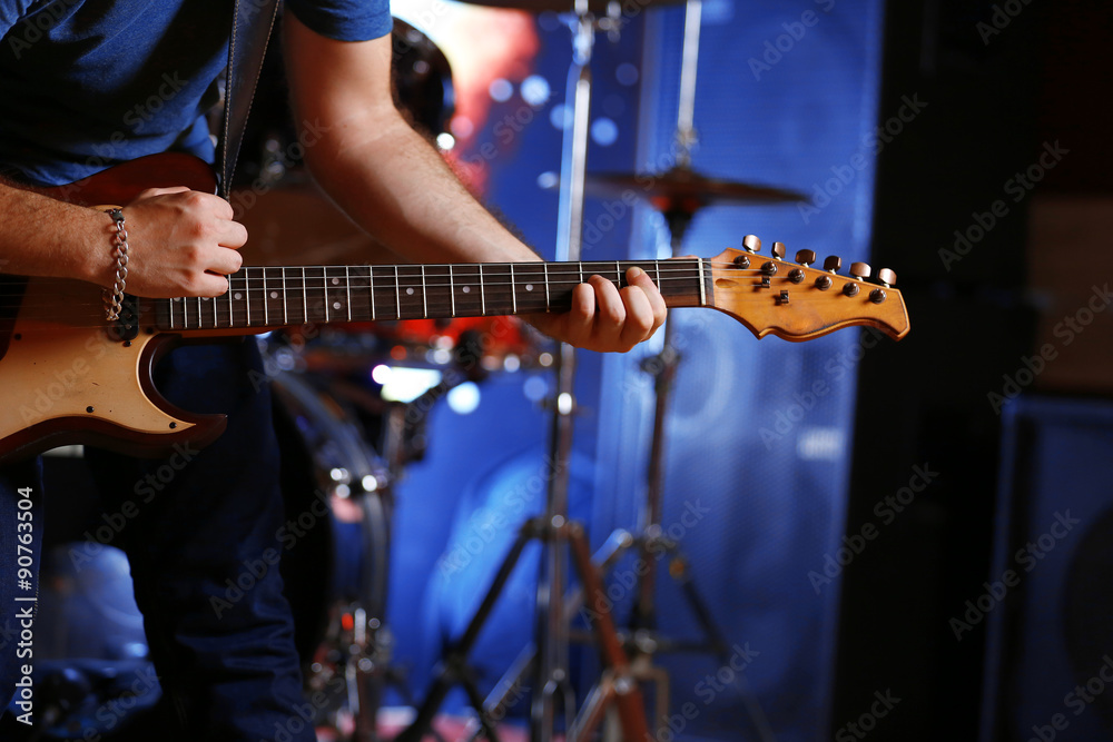 Fototapeta premium Young man playing on electric guitar close up