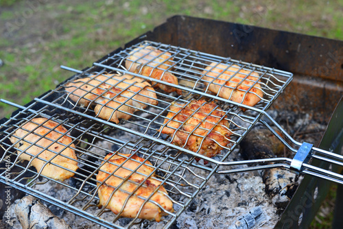 Barbecue chicken over an open fire in summer