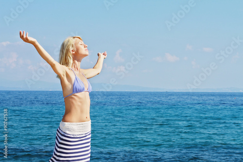 Attractive Blonde Woman  Breathing Happy With Raised Arms, freedom concept, sea, sun, summer, holiday, vacation.