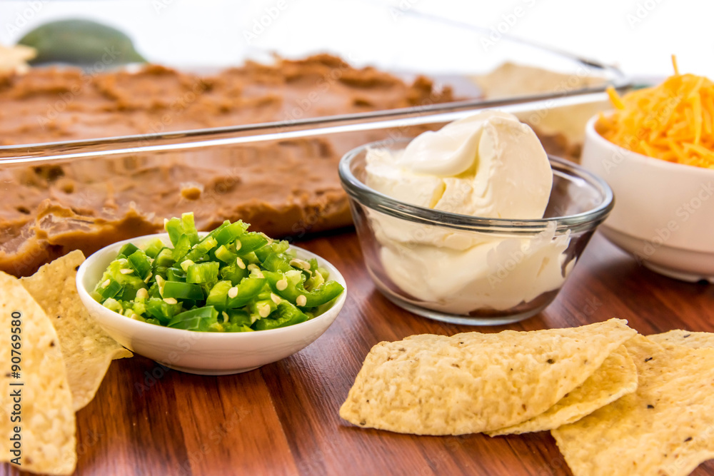 preparation of bean dip with jalapenos, sour cream and cheddar c preparation of bean dip with jalapenos, sour cream and cheddar c