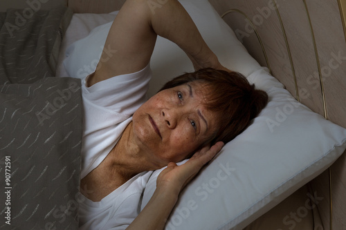 Foto Senior woman cannot sleep at nighttime due to insomnia