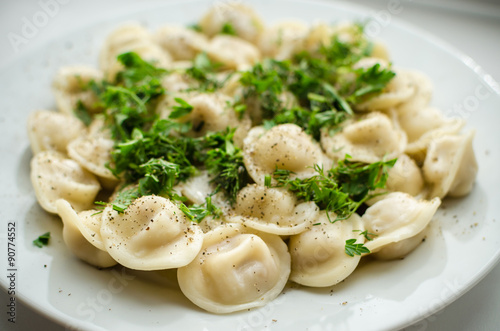 Boiled russian dumplings on the plate with parsley