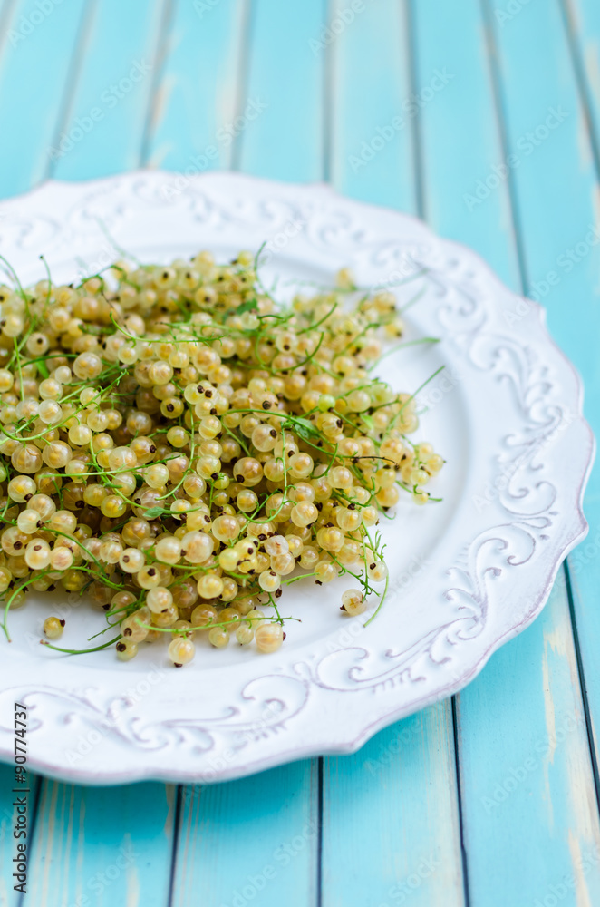 Fresh white currant on plate on rustic wooden turquoise background Fresh white currant on plate on rustic wooden turquoise background
