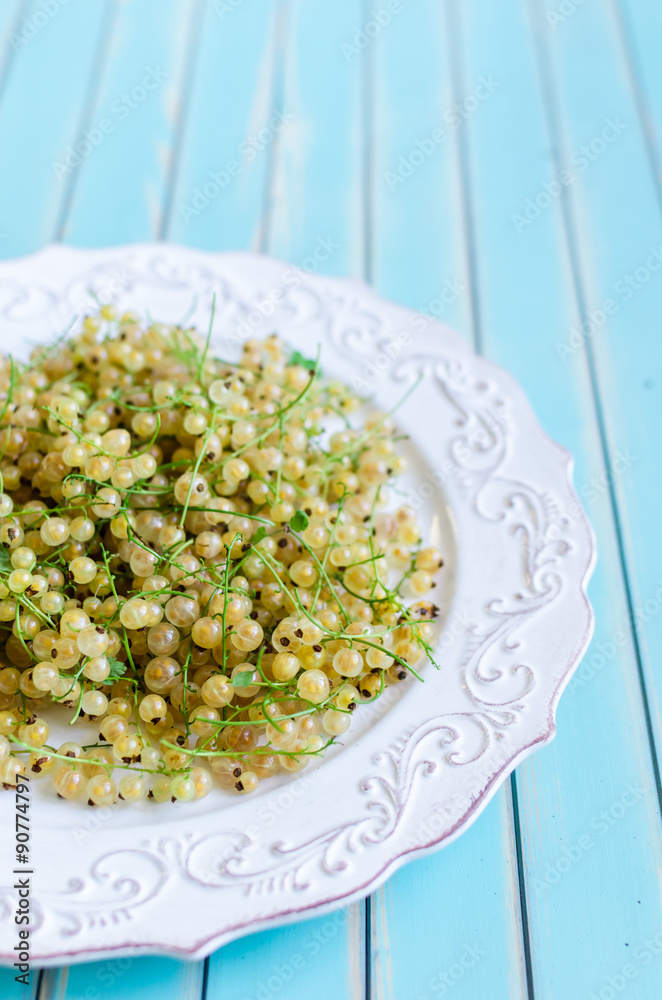 Fresh white currant on plate on rustic wooden turquoise background Fresh white currant on plate on rustic wooden turquoise background