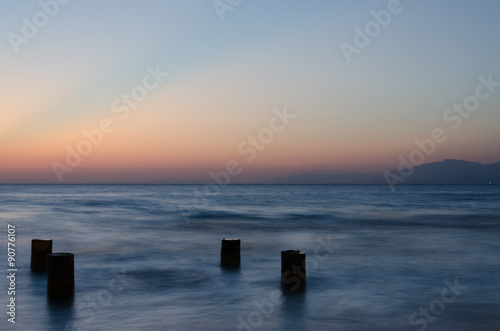 Columns from pier in sea after sunset taken with long shutter time