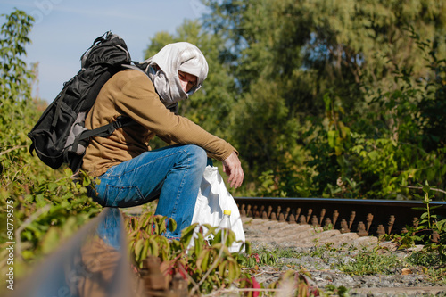 Man acting as a refugee on a railway