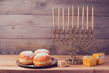 Jewish holiday hanukkah celebration with vintage menorah over wooden background