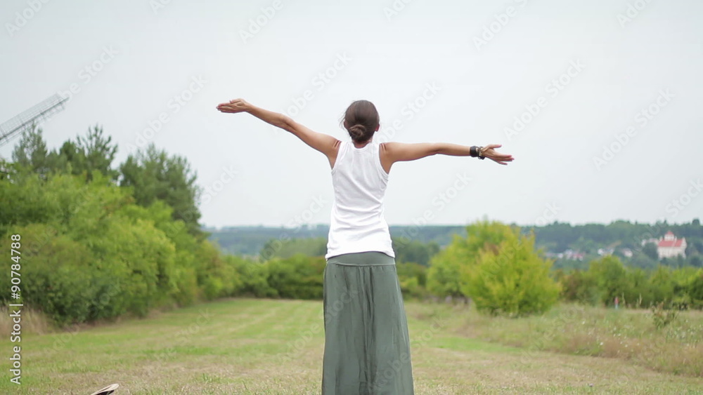 Young woman enjoying the summer and throwing a hat on a field, rear view Young woman enjoying the summer and throwing a hat on a field, rear view