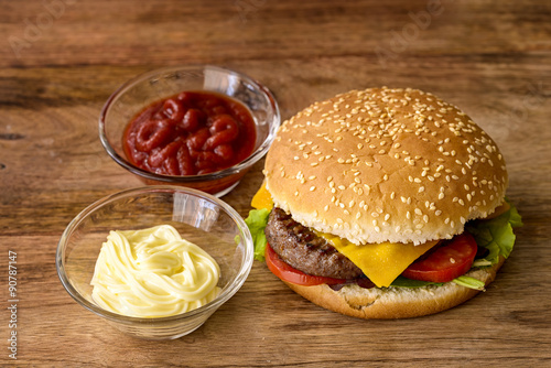 cheeseburger, cheddar, burger, salad and tomato with mayonnaise and ketchup on wood