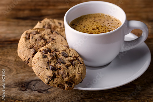 cup of coffee with chocolate cookies on wood