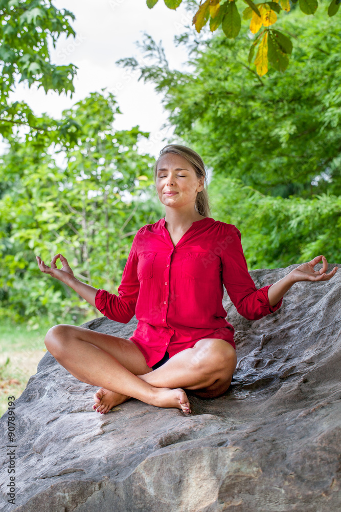 outdoors meditation - smiling young yoga woman escaping in closing eyes,relaxing in sitting in lotus pose on a big stone, summer daylight outdoors meditation - smiling young yoga woman escaping in closing eyes,relaxing in sitting in lotus pose on a big stone, summer daylight