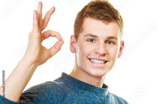 Young man showing ok hand sign gesture photo