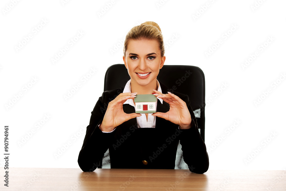Young smile businesswoman presenting a model house Young smile businesswoman presenting a model house