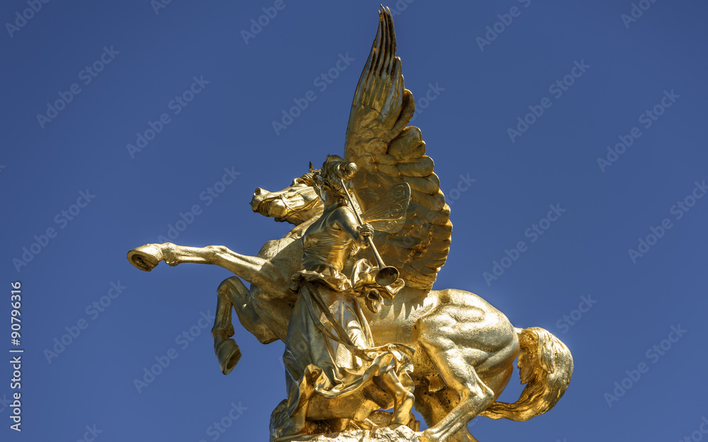 Fototapeta premium Bronze statue of Pegasus and angel, against pure blue sky, Pont Alexandre III and the dome of Les Invalides (Paris, France).