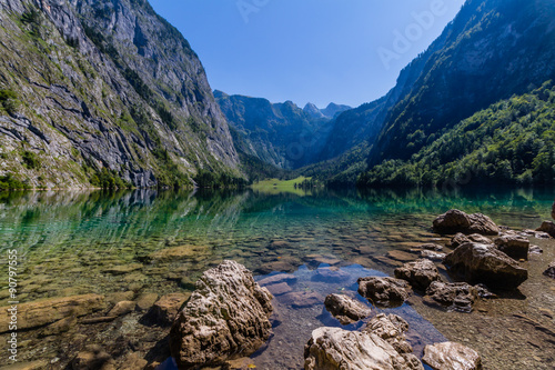 Beautiful landscape of alpine lake with crystal clear green water and mountains in background, Obersee, Germany