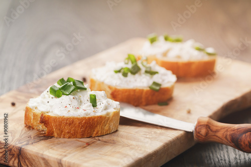 crunchy baguette slices with cream cheese and green onion on