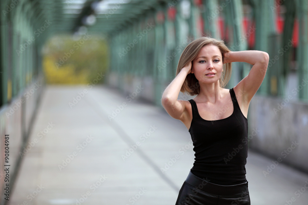 Young beautiful woman posing on a bridge