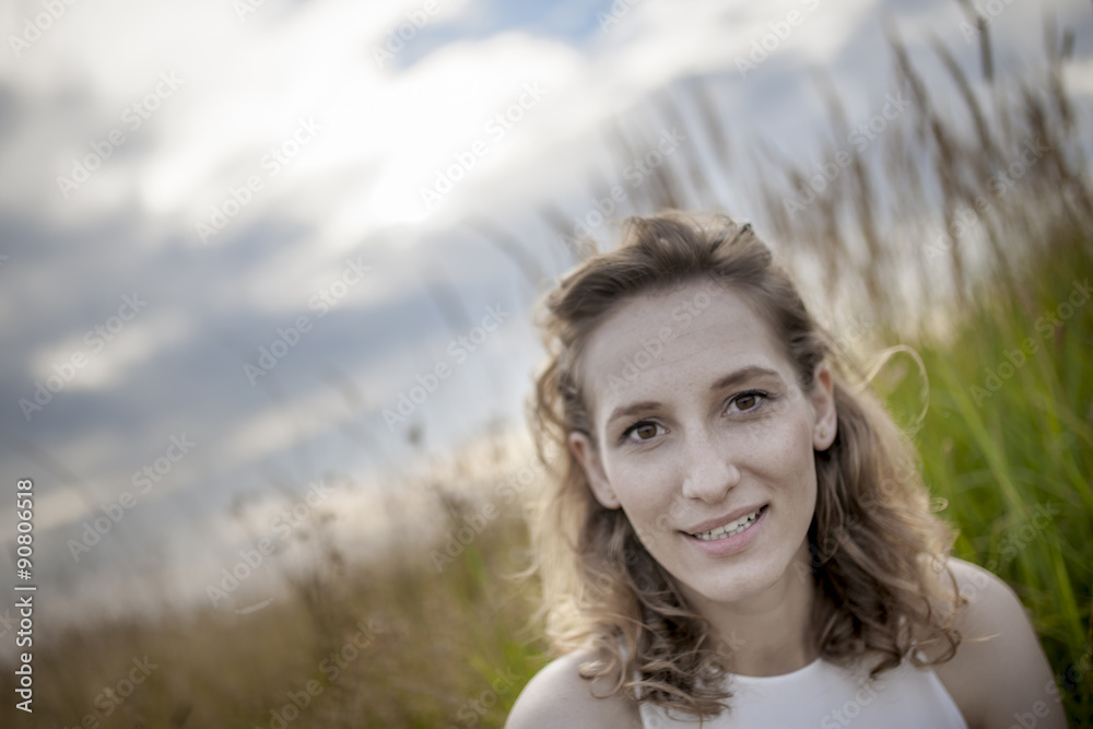 Happy woman relaxing on meadow. Sitting with happy expression on her face. Beautiful summer day on field. Happy woman relaxing on meadow. Sitting with happy expression on her face. Beautiful summer day on field.