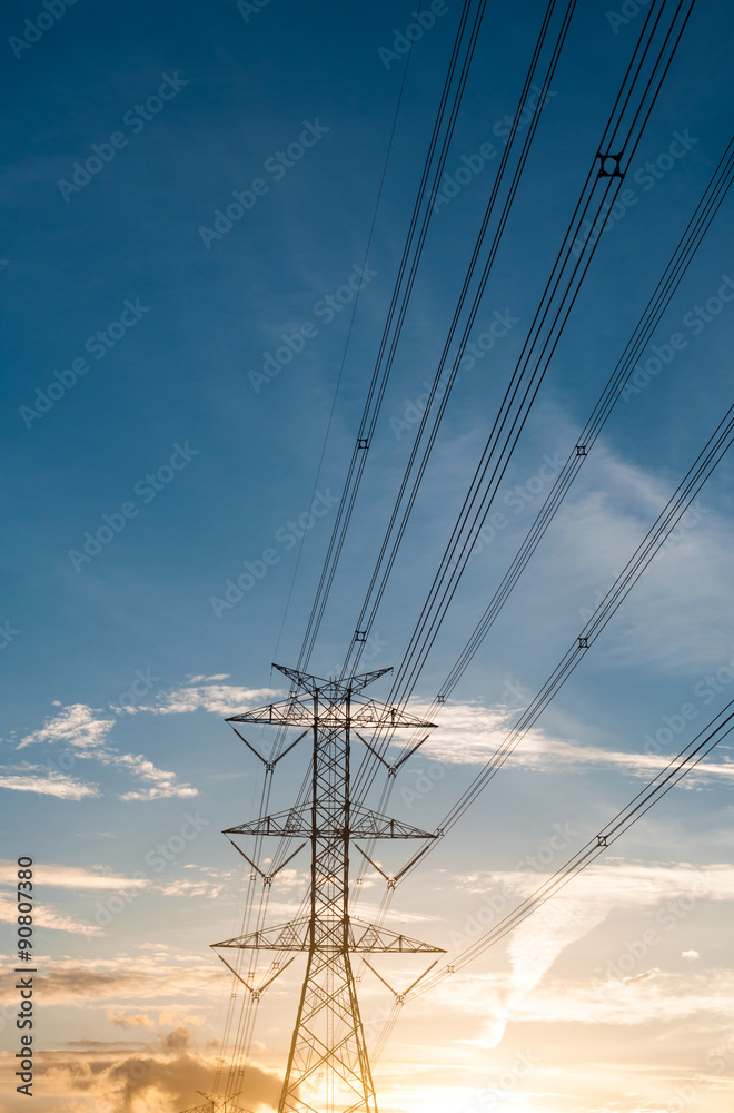 High voltage transmission lines isolated on orange and blue sky,