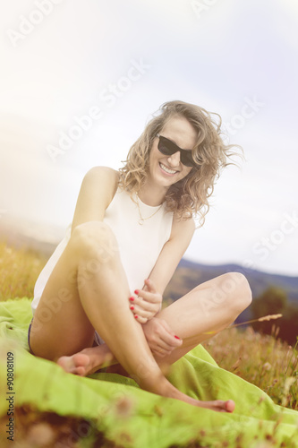 Happy woman relaxing on meadow. Beautiful summer day on field.