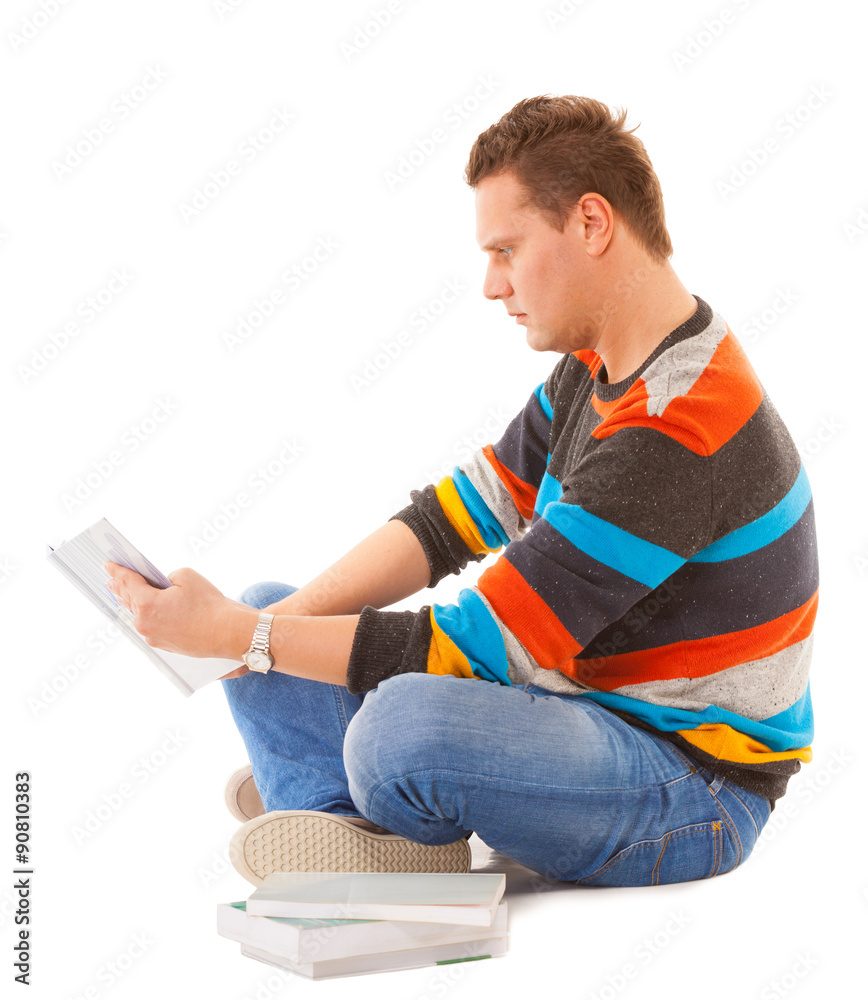 Man college student sitting and reading book studying for exam Man college student sitting and reading book studying for exam