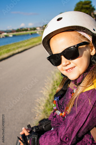 Little girl wearing in roller skates protection outdoors © Vira Monastyrska