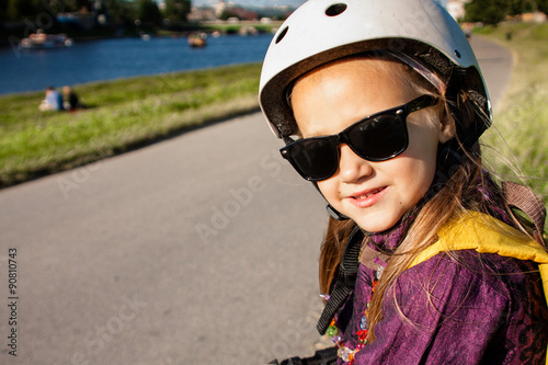 Cute little girl wearing in roller skates protection outdoors © Vira Monastyrska