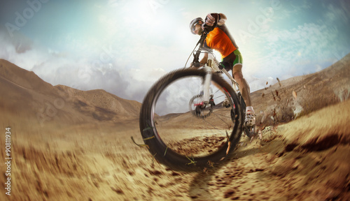 Sport. Mountain Bike cyclist riding single track in desert
