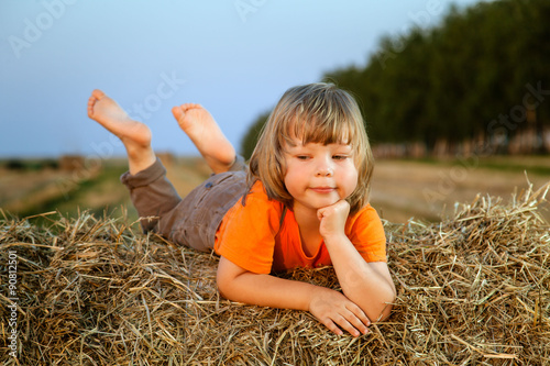 boy in a haystack in the field