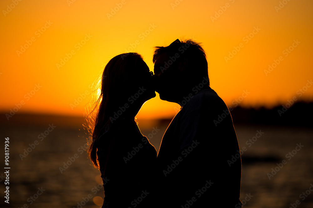 Young couple kissing on the beach sunset