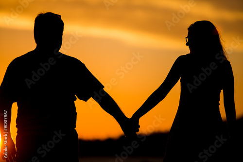 Young couple walk on the sunset