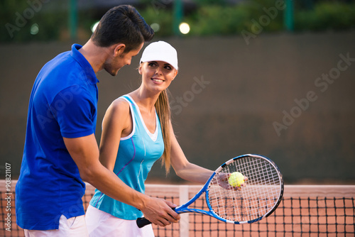 Man training woman how to play in tennis © Drobot Dean