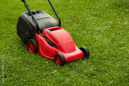 red lawnmower on green grass