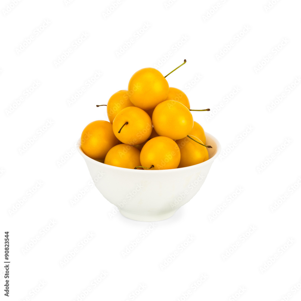 Handful of yellow cherry plums in ceramic bowl - isolated on white background