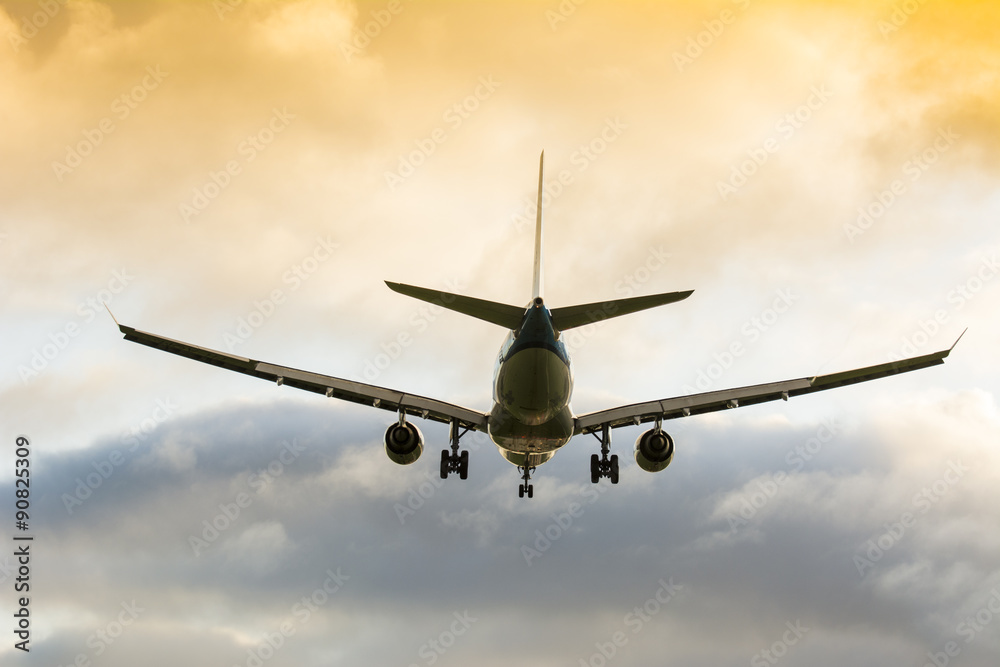 Obraz premium Plane is flying to the runway. Nice colorful cloudy background.