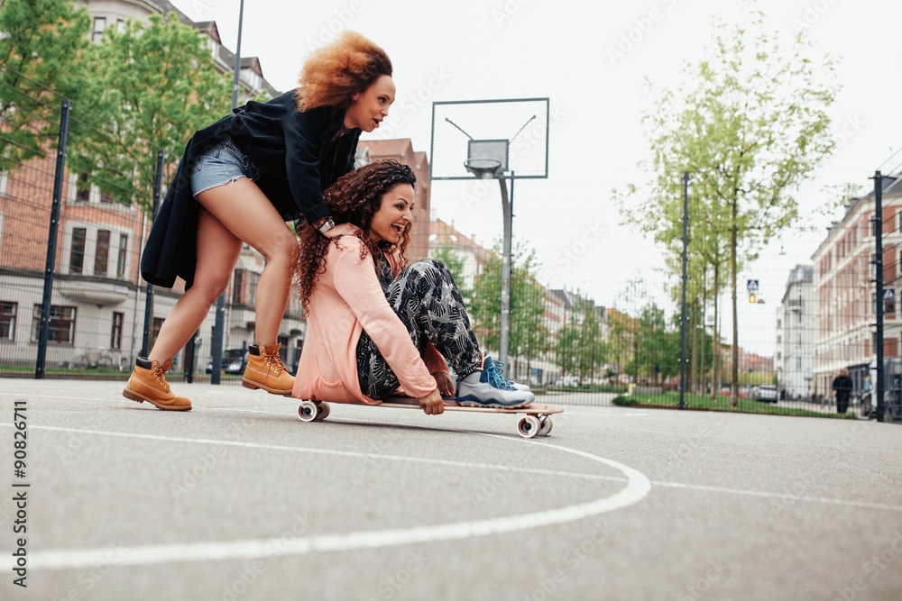 Young women having fun together with skateboard Young women having fun together with skateboard