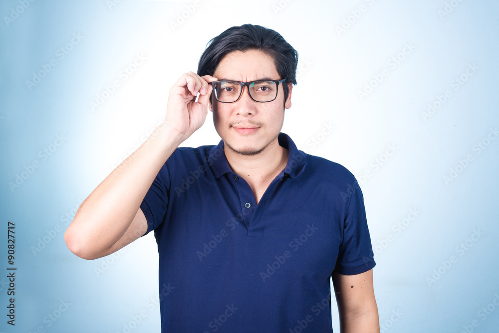 Handsome Asian man looking up while holding glasses with hand, o Handsome Asian man looking up while holding glasses with hand, o
