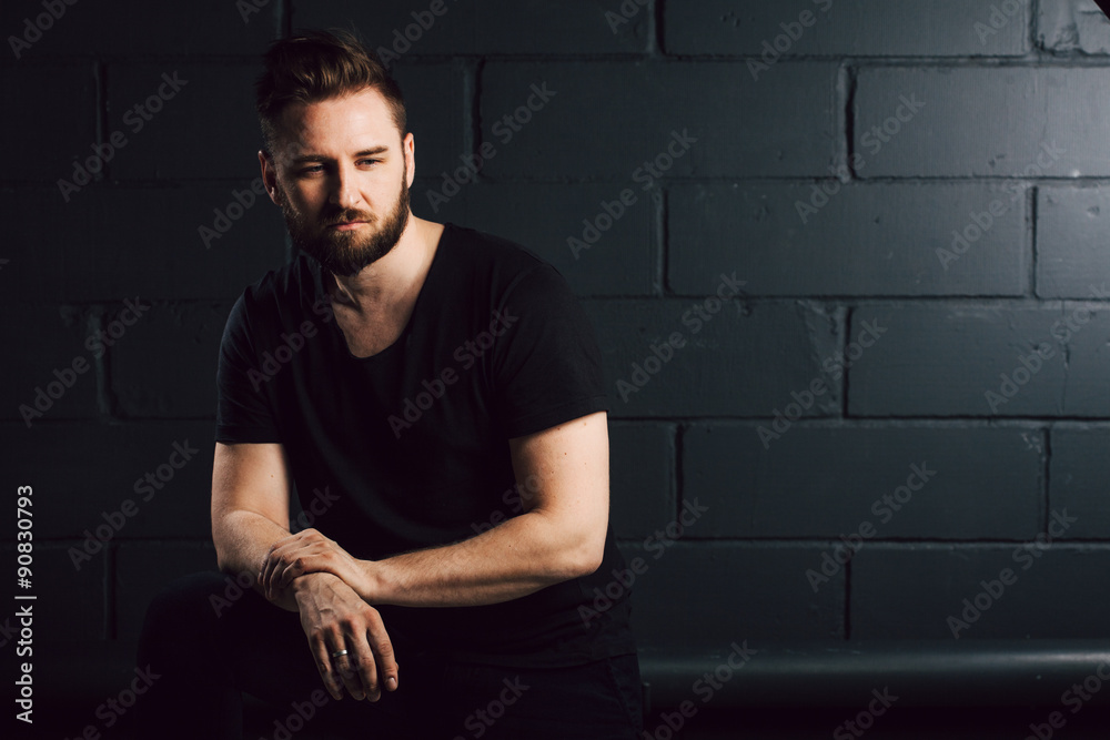 attractive men with beard in black shirt having problems in his life near brick wall attractive men with beard in black shirt having problems in his life near brick wall
