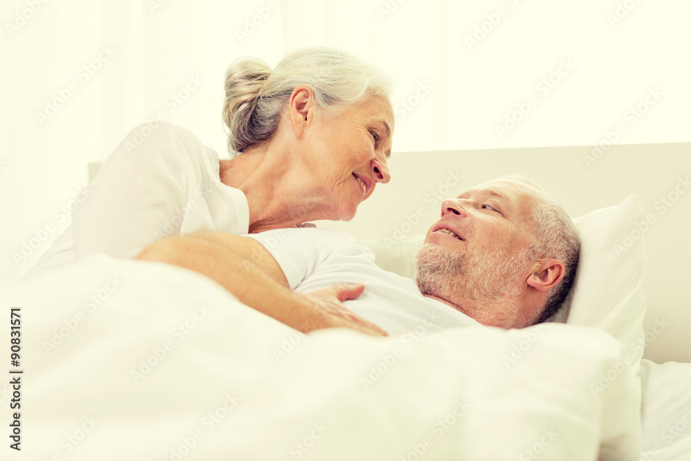 happy senior coupler lying in bad at home happy senior coupler lying in bad at home
