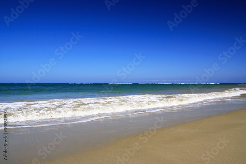 Sea waves with foam on white tropical sandy beach