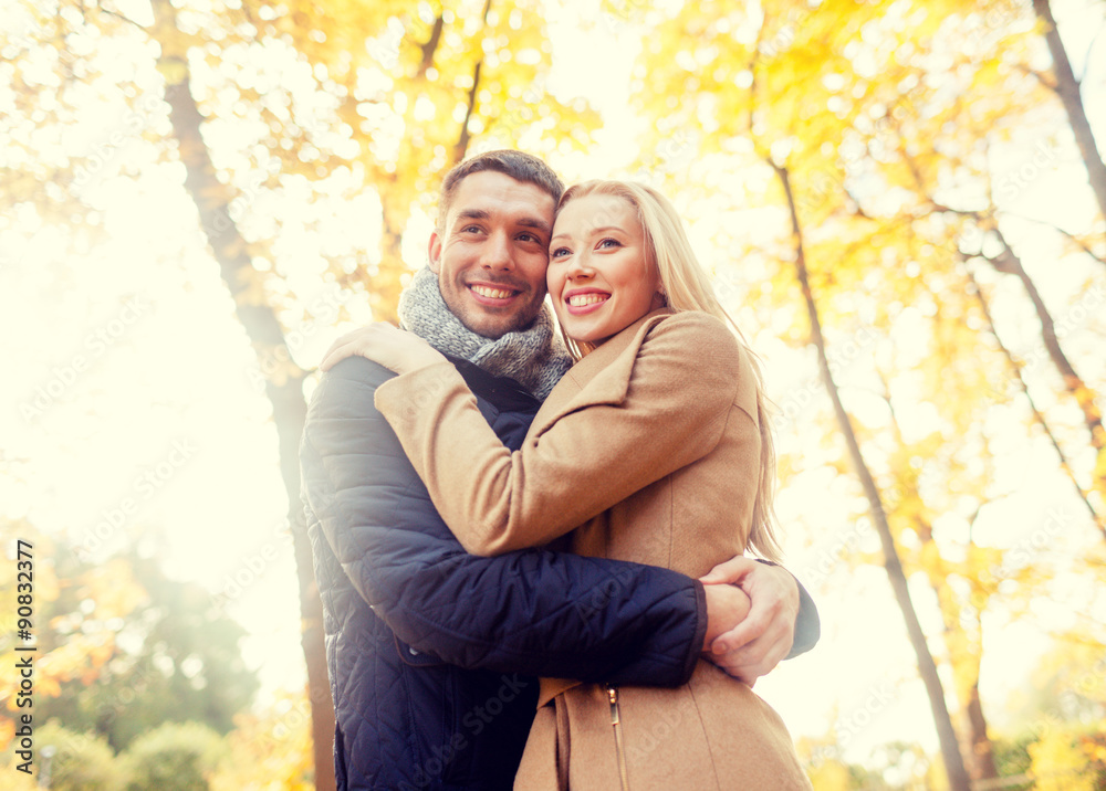 smiling couple hugging in autumn park smiling couple hugging in autumn park