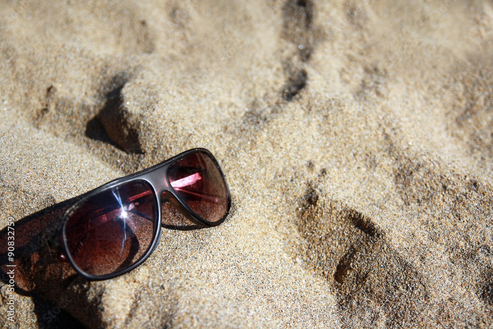 Sunglasses on sandy beach. Travel concept