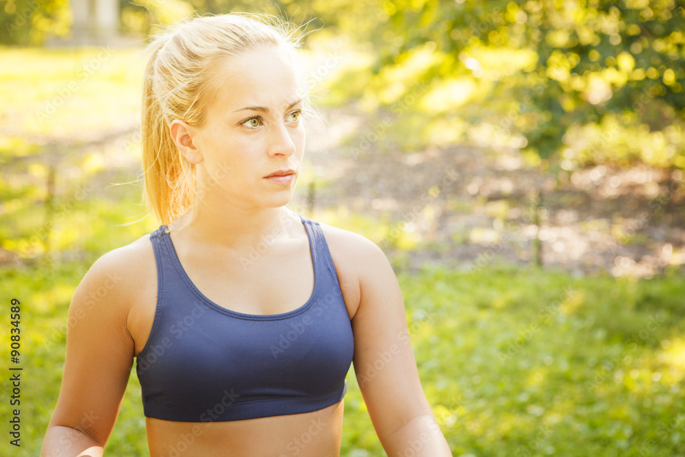 A pensive young woman in athletic wear in the park. A pensive young woman in athletic wear in the park.