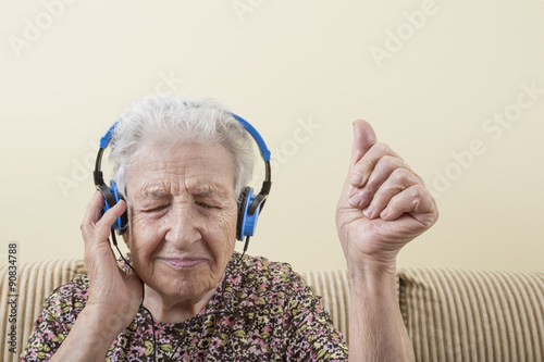 senior woman listening music with headphones