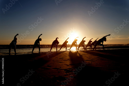 yoga in group as silhouette at sunset
