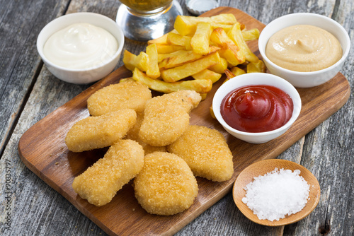 chicken nuggets with french fries and different sauces