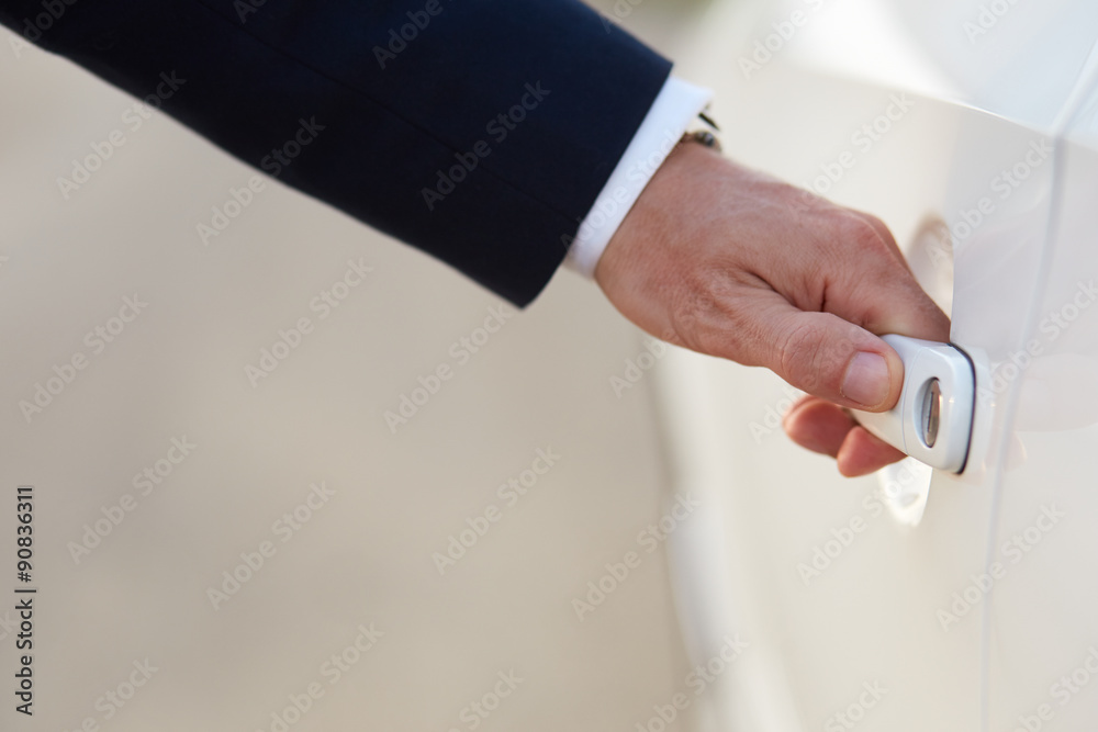 Businessman opening a car door