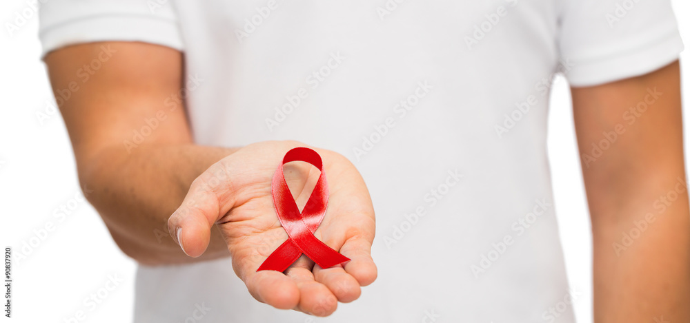 hand with red aids or hiv awareness ribbon - obrazy, fototapety, plakaty 