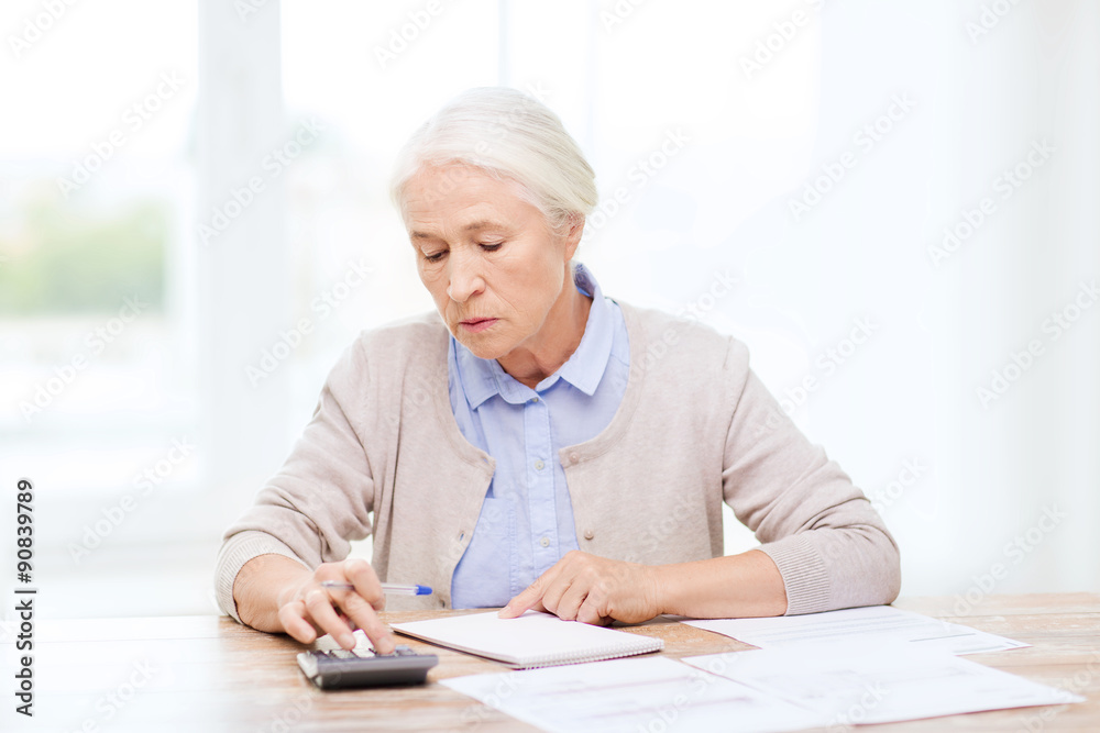 senior woman with papers and calculator at home senior woman with papers and calculator at home