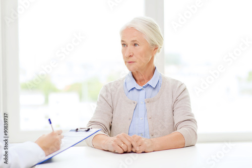 doctor with clipboard and senior woman at hospital